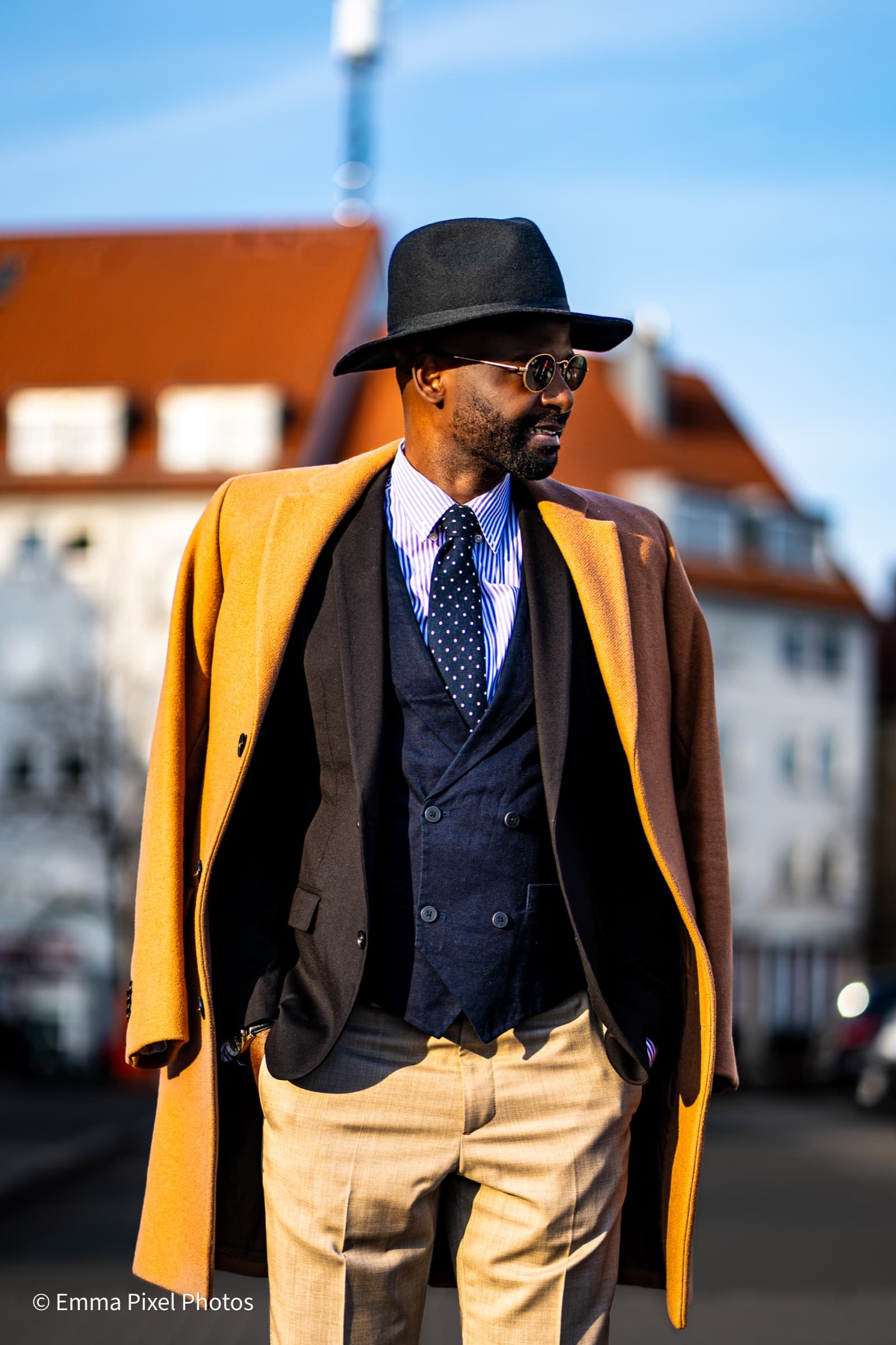 Three-quarter portrait, mustard coat, urban backdrop