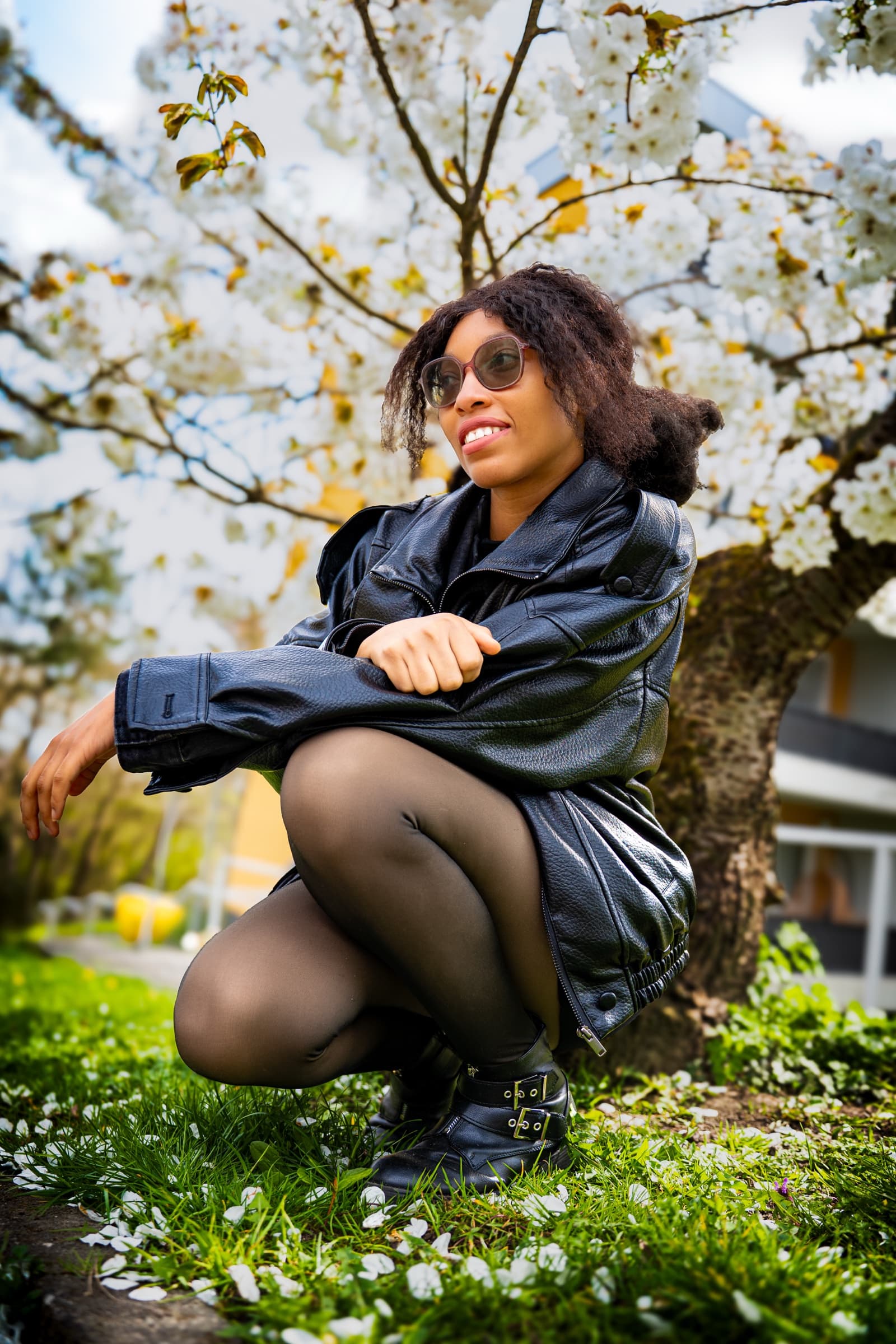 Crouching among petals, leather jacket and blossoms
