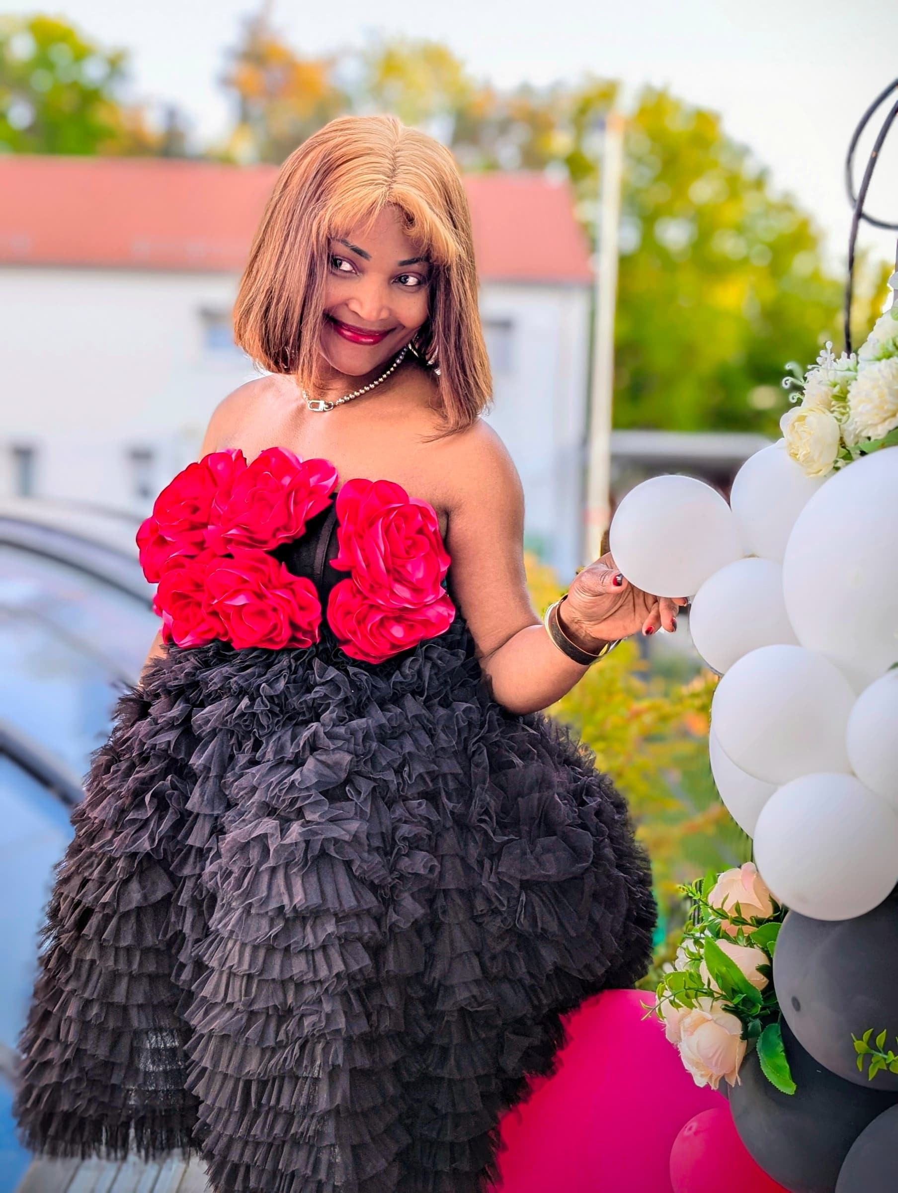 Black ruffle dress with red roses, balloons backdrop