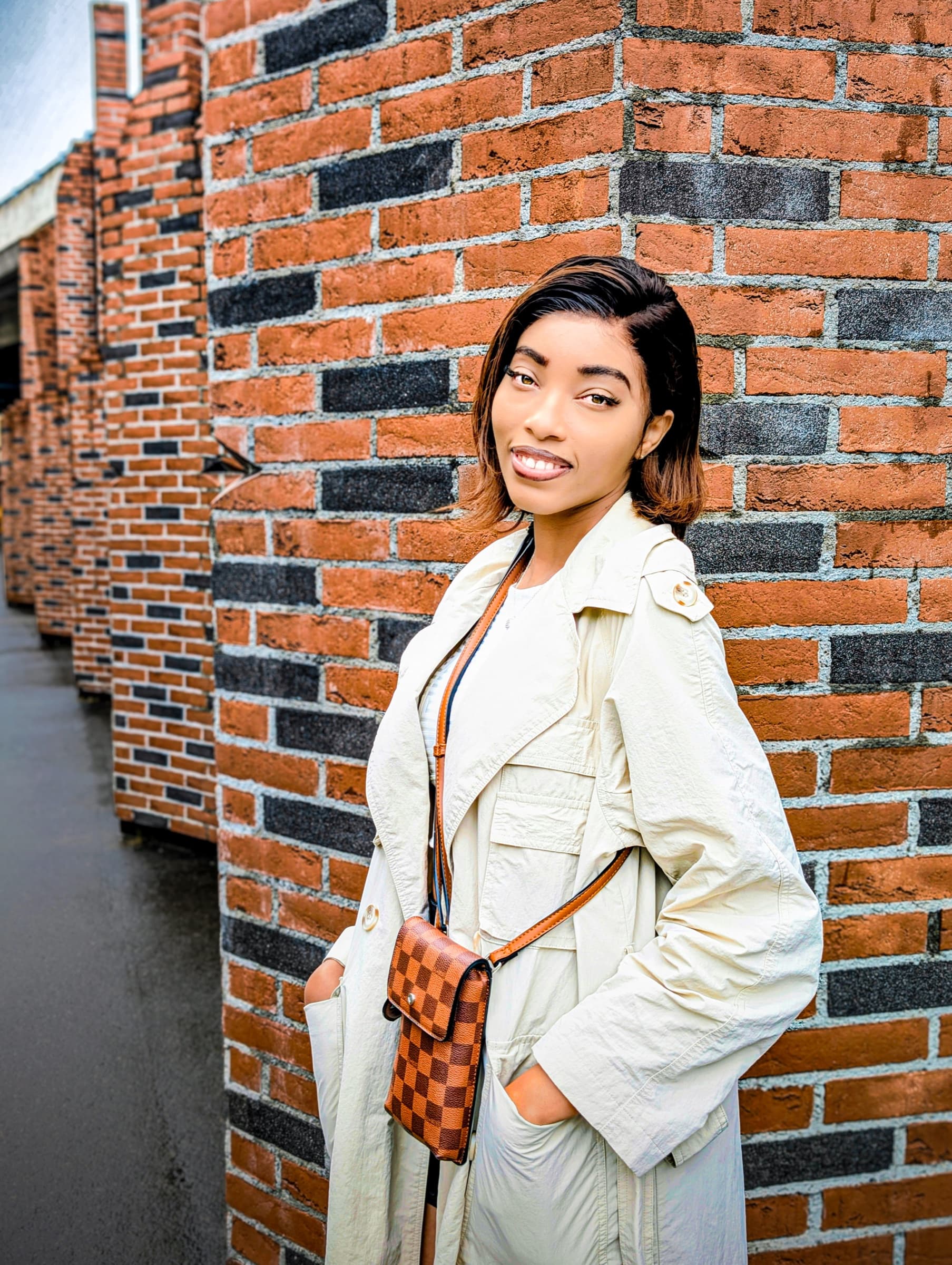 White trench coat, brick wall close-up, urban editorial